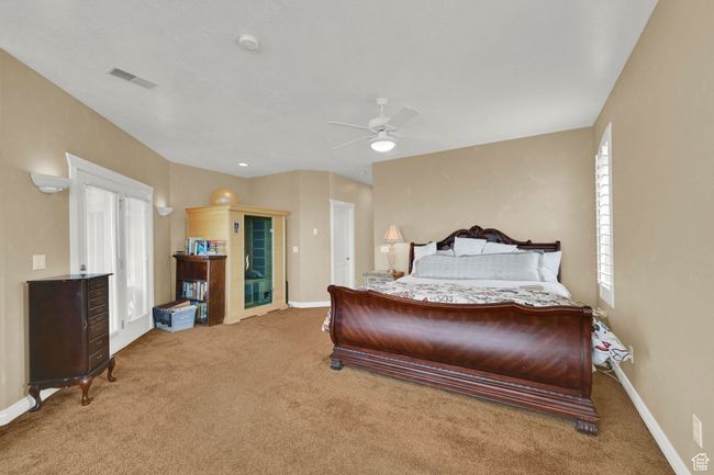 Carpeted bedroom featuring baseboards, ceiling fan, and visible vents | Image 27
