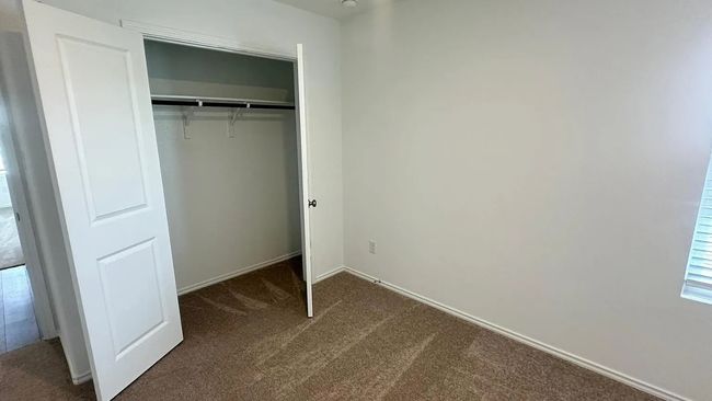 Unfurnished bedroom featuring dark carpet and a closet | Image 21