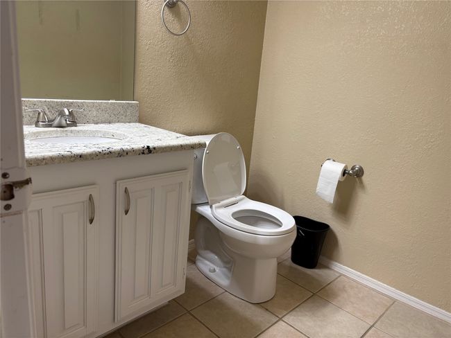 Bathroom featuring tile patterned floors, a textured wall, toilet, and vanity | Image 12