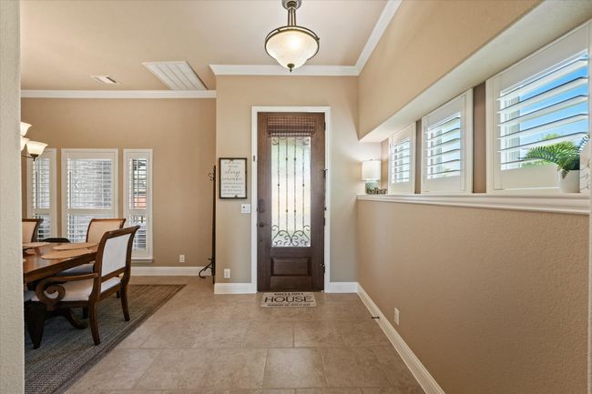 Entrance foyer with baseboards, crown molding, visible vents, and light tile patterned floors | Image 8