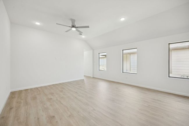 Empty room featuring light wood-style floors, a ceiling fan, vaulted ceiling, and recessed lighting | Image 16