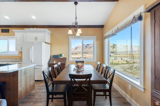 Dining space featuring a wealth of natural light, a chandelier, baseboards, and dark wood-style floors | Image 9