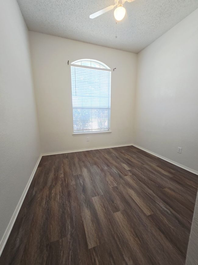 Spare room featuring wood finished floors, a textured ceiling, ceiling fan, and baseboards | Image 21
