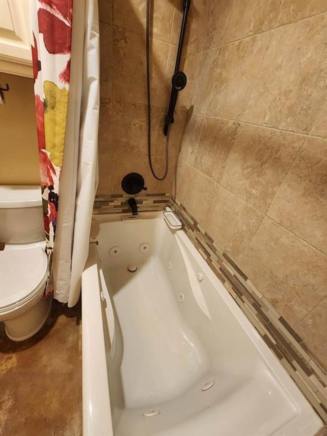 Full bath featuring a combined bath / shower with jetted tub and toilet | Image 18