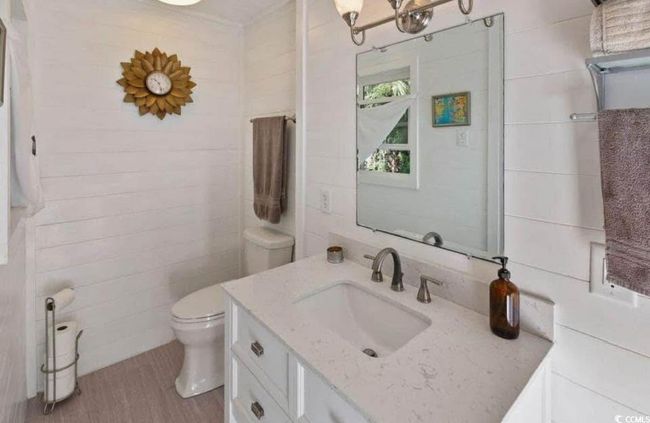 Half bathroom with toilet, vanity, and wood finished floors | Image 16