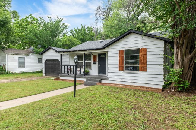 Ranch-style home with a porch, a garage, driveway, a front yard, and roof with shingles | Image 4