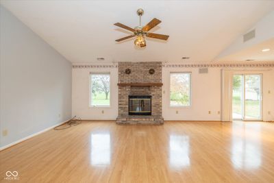 Open concept living room with brick wood burning fireplace | Image 2