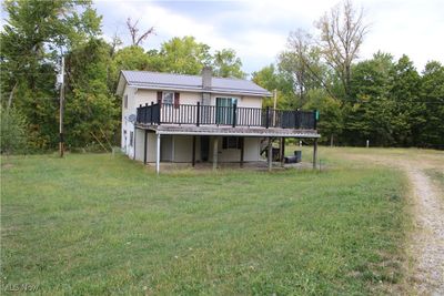 Back of house featuring a deck and a yard | Image 1