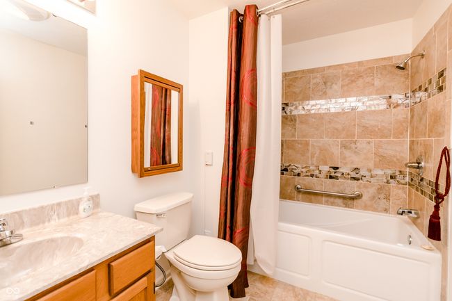 full bathroom featuring shower / tub combo, toilet, vanity, and tile patterned flooring | Image 19