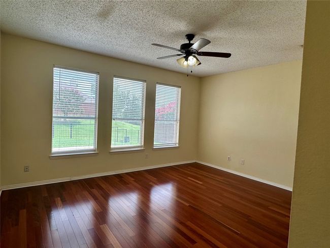 Unfurnished room featuring a ceiling fan, a textured ceiling, and dark wood-style floors | Image 11