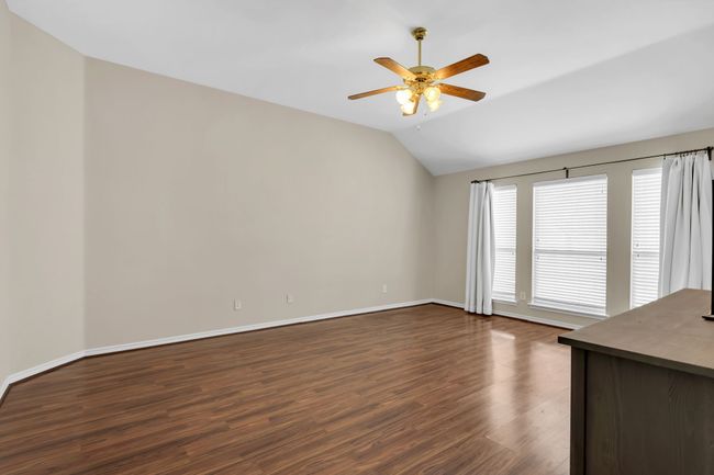 Large Primary Bedroom with dark wood-type flooring, lofted ceiling and ceiling fan | Image 19