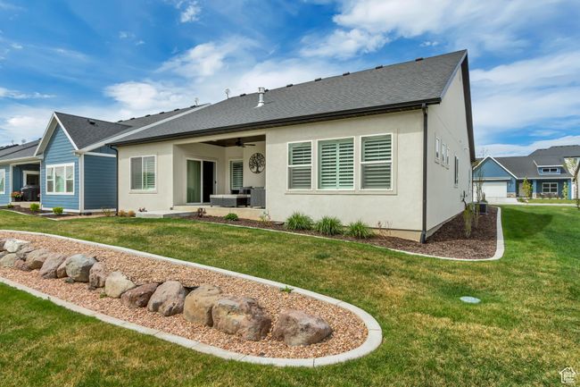 Back of house featuring a shingled roof, ceiling fan, a yard, a patio, and stucco siding | Image 30