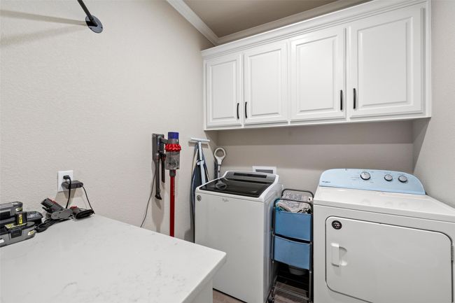 Laundry area featuring cabinet space, independent washer and dryer, and crown molding | Image 19
