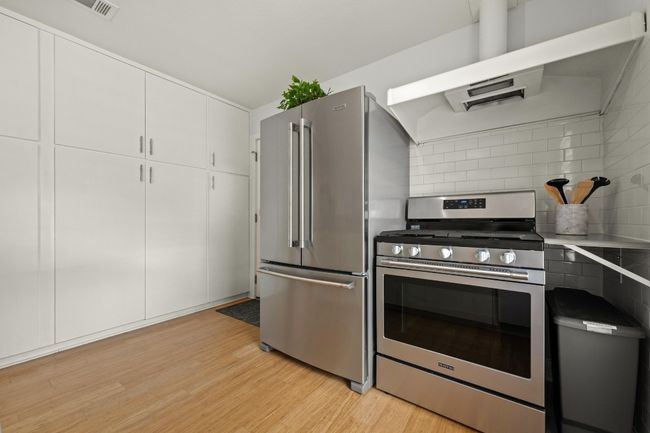 Floor to ceiling cabinetry offers abundant storage in the kitchen. | Image 12