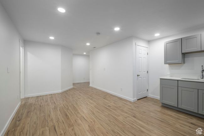 Basement with light wood finished floors, a sink, baseboards, and recessed lighting | Image 29