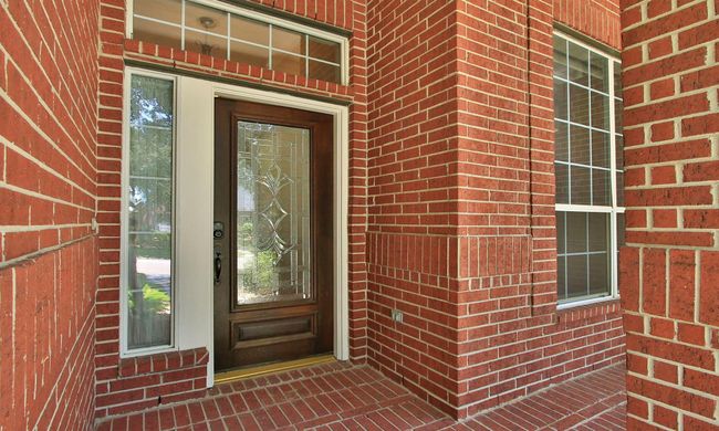 Elegant glass and wood front door, with a thoughtfully placed exterior outlet for holiday decorations | Image 6