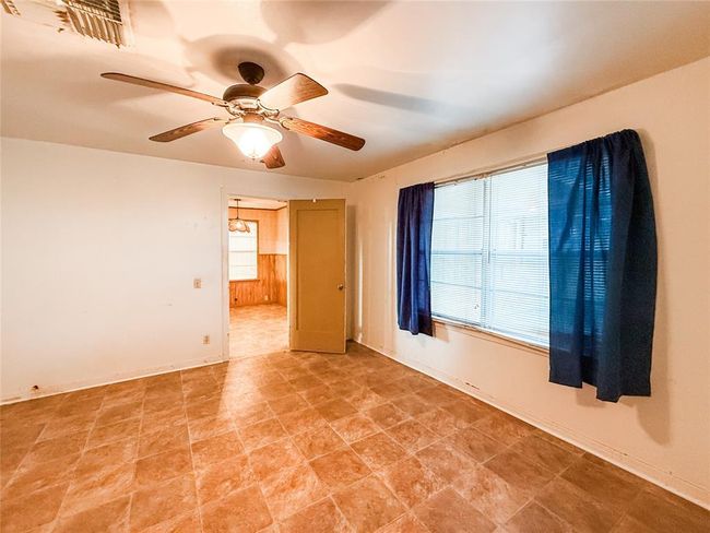 Spacious primary bedroom with abundant natural light, ceiling fan, and easy-to-maintain flooring. Ideal for relaxation and comfort. | Image 9