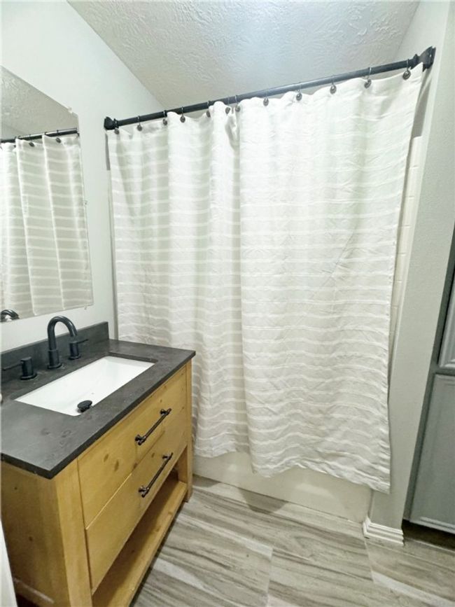 Bathroom with wood finished floors, vanity, and a textured ceiling | Image 11