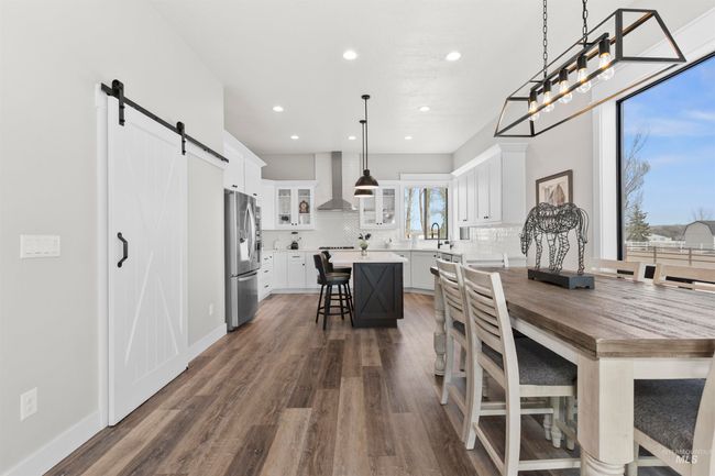 Dining space with a barn door, dark wood finished floors, and recessed lighting | Image 15