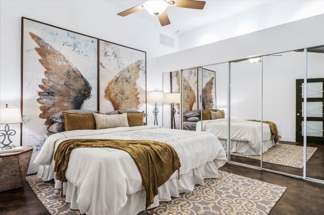 Primary bedroom with a large closet, finished stained concrete floors, and a ceiling fan | Image 28