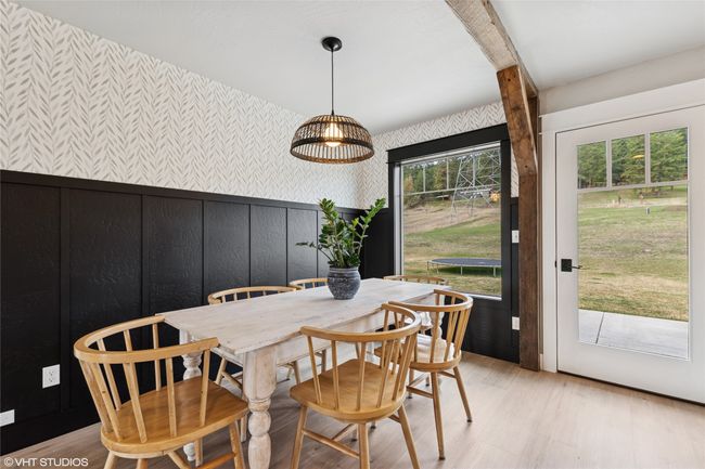 Dining room featuring light wood-type flooring, wallpapered walls, and a wainscoted wall | Image 16