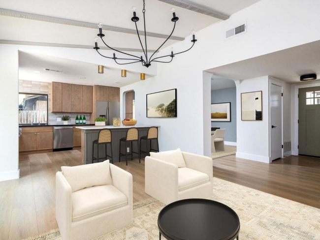 Living area with light wood finished floors, a chandelier, and arched walkways | Image 9
