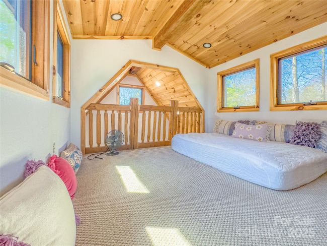 Additional view of family room. The walls are adorned with customized wood paneling, bringing a rich, natural warmth that compliments the rustic elegance of the fireplace. | Image 23