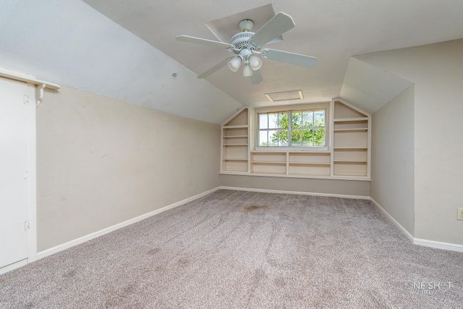 Bonus room featuring built in shelves, vaulted ceiling, ceiling fan, and carpet flooring | Image 25