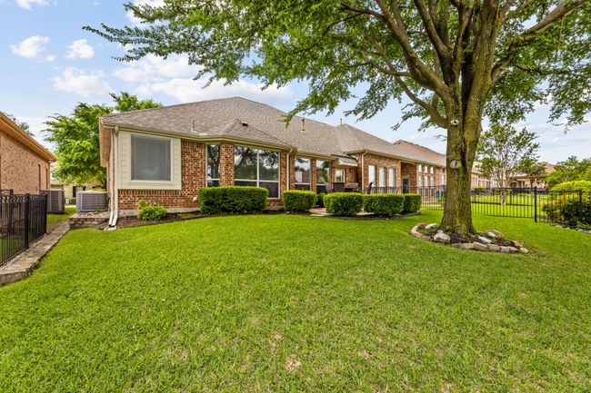 Rear view of property with brick siding, cooling unit, and a shingled roof | Image 21