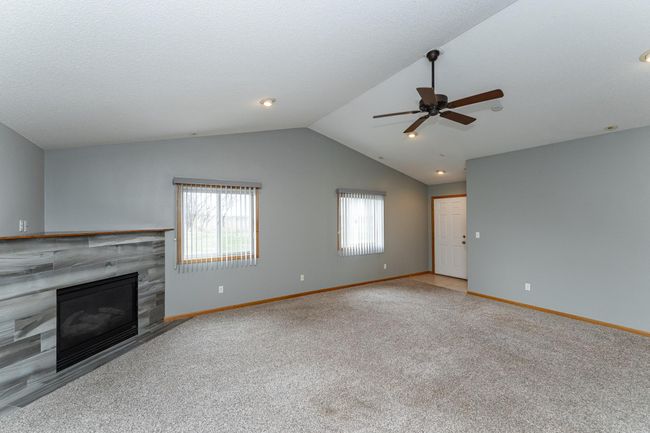 Elegant corner gas fireplace and vaulted ceilings. | Image 7