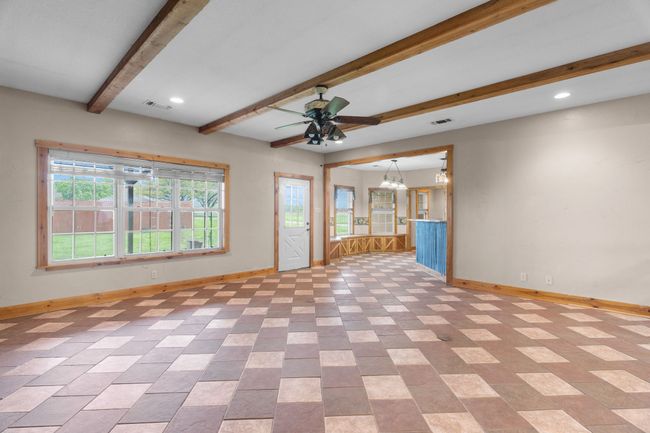 Unfurnished living room with visible vents, baseboards, and ceiling fan with notable chandelier | Image 22