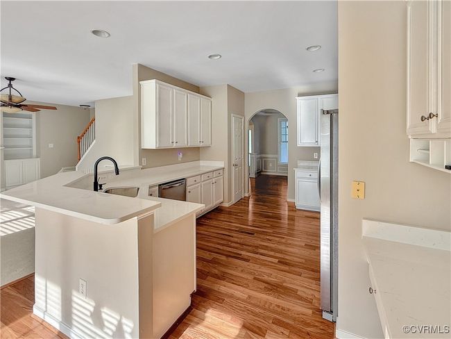 Kitchen featuring arched walkways, a ceiling fan, stainless steel appliances, light wood-style floors, and recessed lighting | Image 5