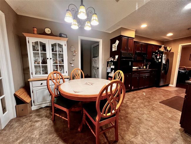 Dining room with a textured ceiling and an inviting chandelier | Image 7