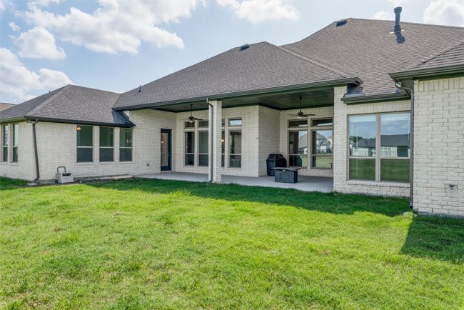 Rear view of property featuring a ceiling fan, roof with shingles, a patio area, and brick siding | Image 30