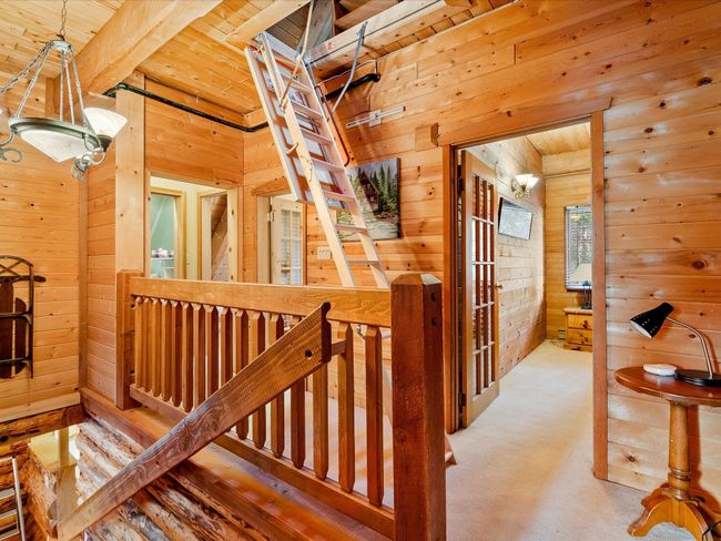Corridor with wooden ceiling, carpet floors, wood walls, an upstairs landing, and beamed ceiling | Image 24