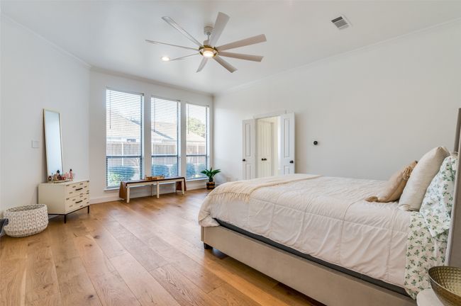 Bedroom with visible vents, crown molding, light wood-style floors, and a ceiling fan | Image 23