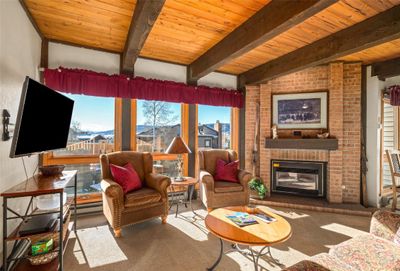 Living room with lofted ceiling with beams, a brick fireplace, and wooden ceiling | Image 3