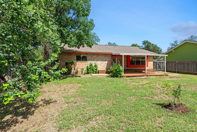 Ranch-style house with a fenced backyard, a wooden deck, brick siding, and a shingled roof | Image 24