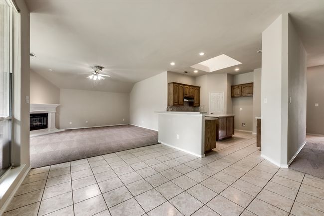 Unfurnished living room featuring light carpet, recessed lighting, lofted ceiling, light tile patterned floors, and a ceiling fan | Image 16