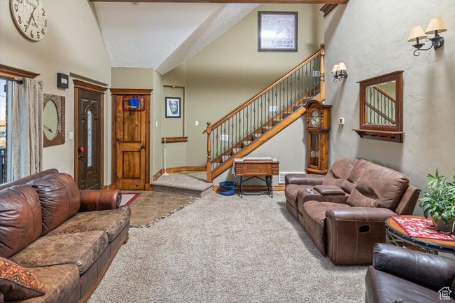 Carpeted living room featuring high vaulted ceiling | Image 6