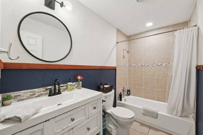 Full bath with toilet, vanity, shower / bath combo, and tile patterned floors | Image 18
