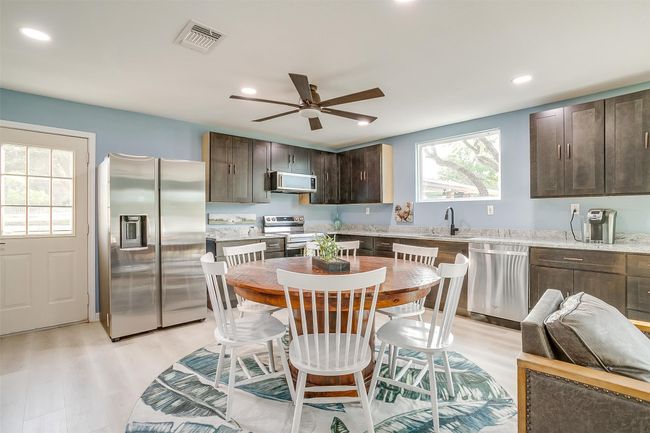 Kitchen featuring a sink, visible vents, dark brown cabinetry, light wood-style floors, and appliances with stainless steel finishes | Image 15