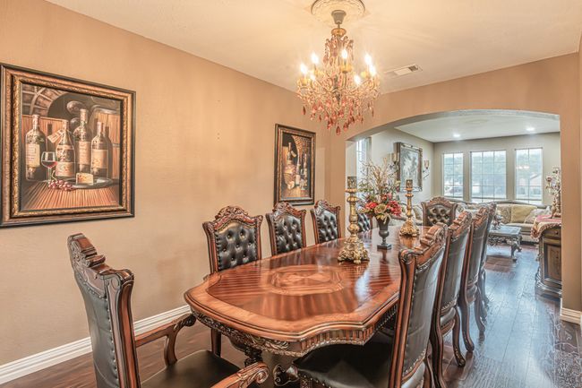Dining space featuring arched walkways, a chandelier, and dark wood-style floors | Image 5