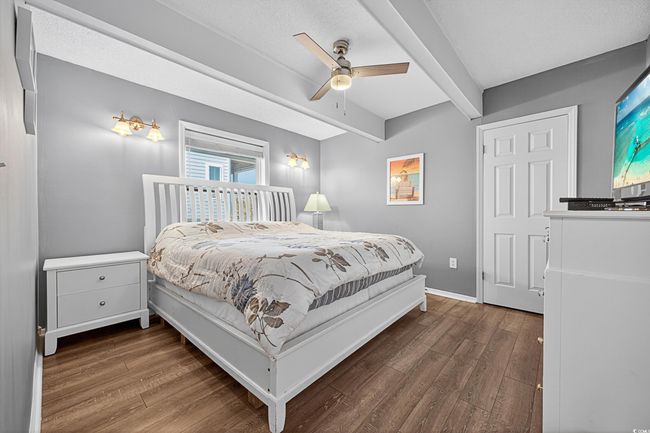 Bedroom featuring wood finished floors, beam ceiling, and ceiling fan | Image 27