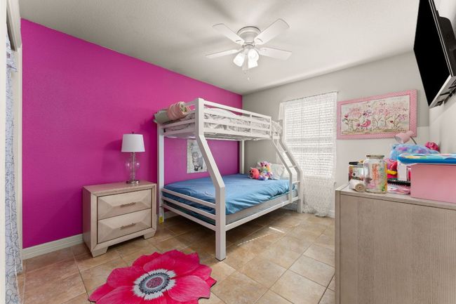 Bedroom with tile patterned floors, ceiling fan, and baseboards | Image 19