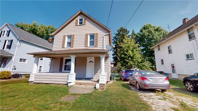 View of front facade with a porch and a front yard | Image 1