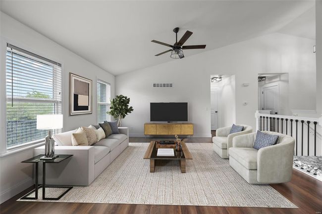 Living room with visible vents, a ceiling fan, wood finished floors, and lofted ceiling | Image 20
