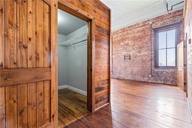 Hallway with wood-type flooring and brick wall | Image 9