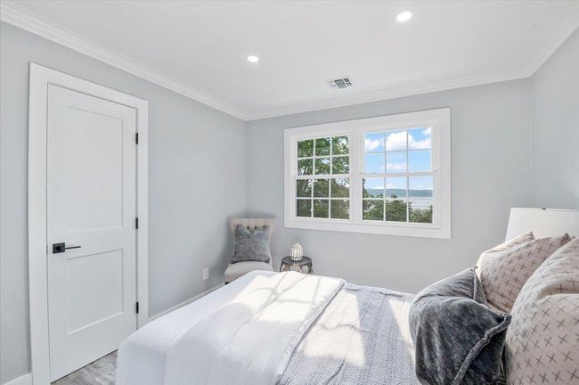 Bedroom with light wood-style flooring, ornamental molding, and recessed lighting | Image 18