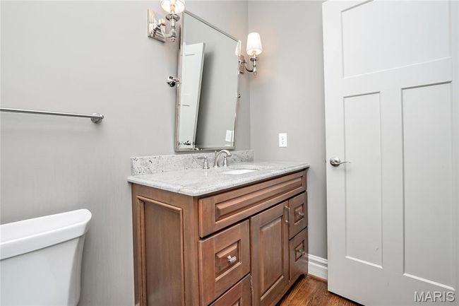 First floor Half Bathroom featuring toilet, wood finished floors, and vanity | Image 16